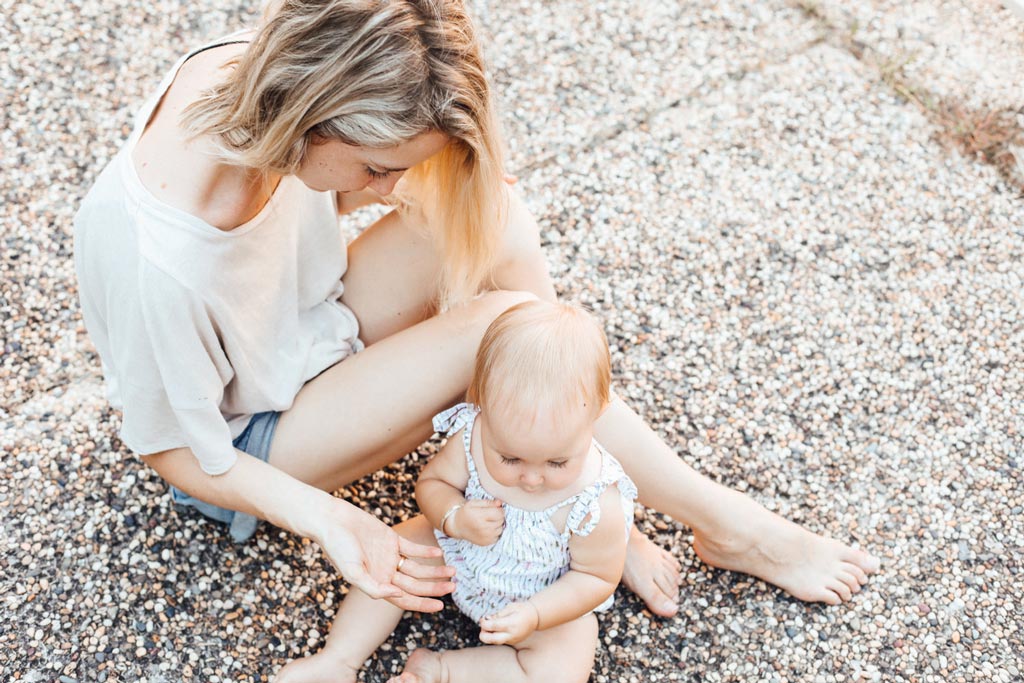A mother sitting outdoors with her baby